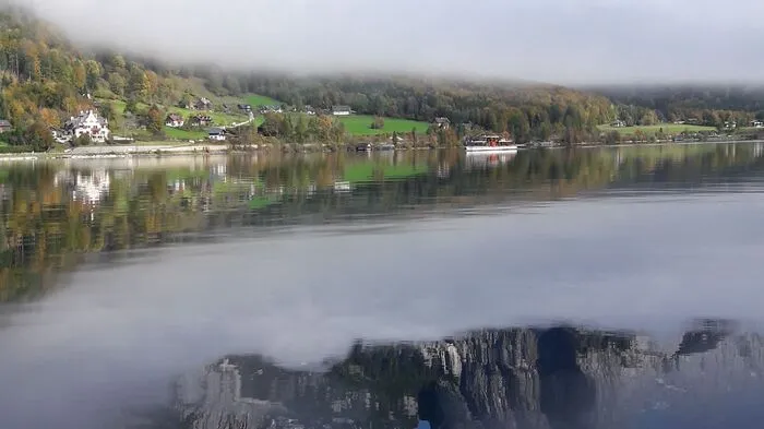 Herbstliche Frühnebel über dem Grundlsee heben sich.