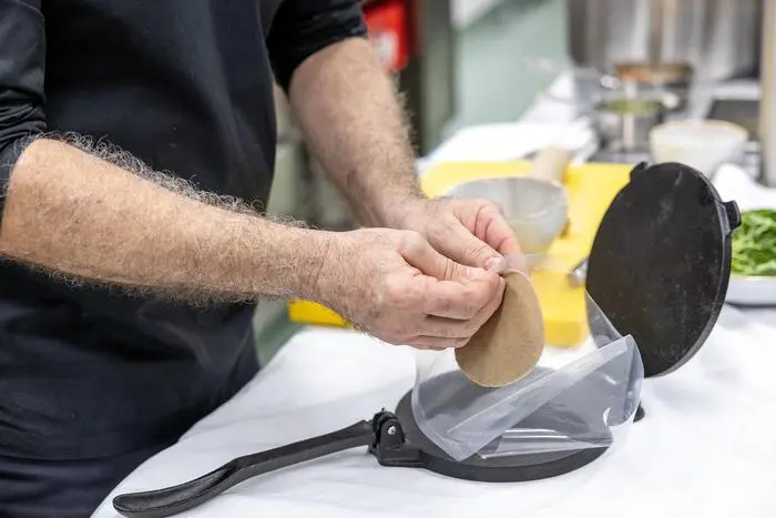 Thomas Gruber formt die Krapfen mit Hilfe einer Tortillapresse, Tacopresse.