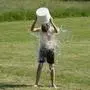 Teenage boy pouring bucket of cold water over his head outdoors. Ice water challenge. Cold water therapy benefits, Teenage boy pouring bucket of cold water over his head outdoors. Ice water challenge. Cold water therapy benefits. model released