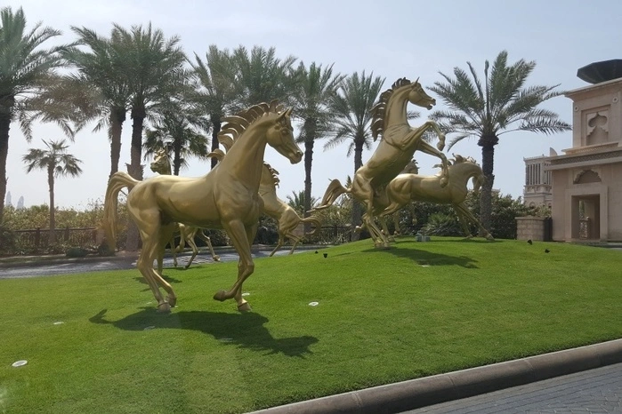 Goldene Pferde an der Einfahrt zu einem Hotel.