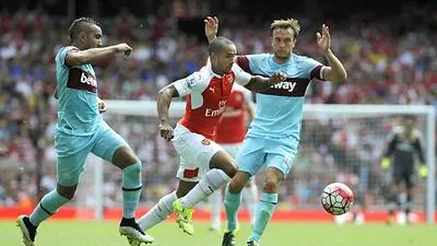 epa04878274 Arsenal's Theo Walcott (C) vies for the ball with West Ham's Mark Noble (R) during the English Premier League soccer match between Arsenal and West Ham at the Emirates Stadium, in London, Britain, 09 August 2015. EPA/GERRY PENNY EDITORIAL USE ONLY. No use with unauthorized audio, video, data, fixture lists, club/league logos or 'live' services. Online in-match use limited to 75 images, no video emulation. No use in betting, games or single club/league/player publications