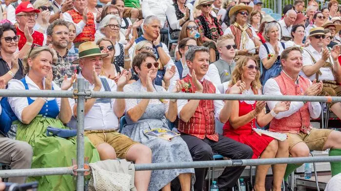 Eine Freilufttribüne mit vielen Menschen in Tracht