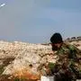 TOPSHOT - A Syrian fighter affiliated with the Hayat Tahrir al-Sham (HTS) group operates the remote for a pickup-mounted rocket launcher firing at Syrian government forces' positions in the northwest of Aleppo province on January 1, 2024. (Photo by Omar HAJ KADOUR / AFP)