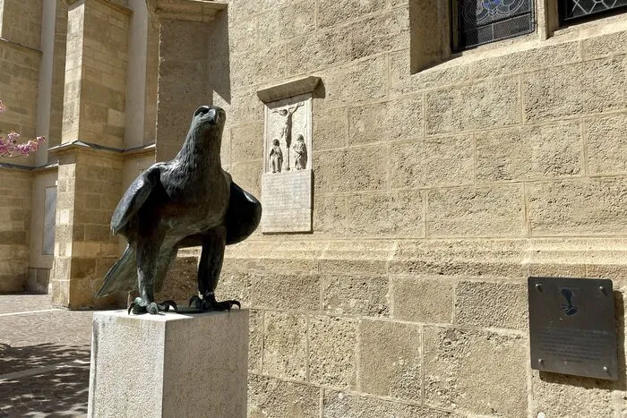Mit stoischer Ruhe übersieht der Bronzeadler den oberen Kirchenplatz