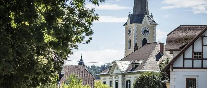Ein Ortskern mit dem Kirchturm im Hintergrund.