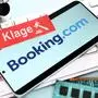 FOTOMONTAGE, Smartphone mit Schriftzug von Booking.com und Zettel mit Aufschrift Klage auf einer Computertastatur, Klage von Hotelbetreibern gegen das Reiseportal *** PHOTOMONTAGE, smartphone with Booking com lettering and note with the word Klage on a computer keyboard, lawsuit by hotel operators against the travel portal
