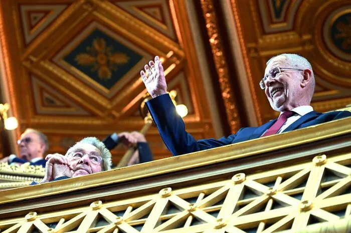 Bundespräsident Alexander Van der Bellen grüßt vom Balkon herab.