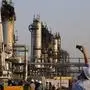 FILE - During a trip organized by Saudi information ministry, a cameraman films Aramco's oil processing facility after the recent Sept. 14 attack in Abqaiq, near Dammam in the Kingdom's Eastern Province, Friday, Sept. 20, 2019.  Iran and Saudi Arabia have agreed to reestablish diplomatic relations and reopen embassies after years of tensions. The two countries released a joint communique about the deal on Friday, March 10, 2023 with China, which apparently brokered the agreement.(AP Photo/Amr Nabil, File)