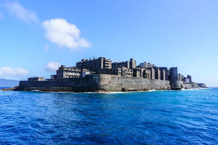 Von 1887 bis 1974 wurde auf der Insel Hashima vor Nagasaki unterseeischer Kohleabbau betrieben. Groß ist die Insel ja nicht: 6,3 Hektar, die Küstenlinie beträgt nur 1,2 Kilometer. Dennoch wohnten hier zeitweise über 5000 Menschen. 1974 wurde das Werk geschlossen und die Arbeiter und ihre Familien verließen die Insel fluchtartig. Wem das Eiland jetzt bekannt vorkommt, der irrt sich nicht: Sie war Inspiration für jene Insel, die im „James Bond“-Streifen „Skyfall“ mit Daniel Craig und Javier Bardem zu sehen ist.