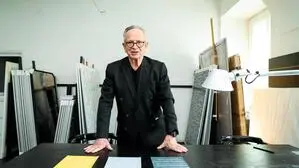 Richard Kriesche in seinem Atelier vor den Entwürfen zu den Titelseiten.
 