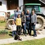 Eine Bauernfamilie steht vor einem grünen Traktor  | Die Familien Zarfl und Lichtenegger