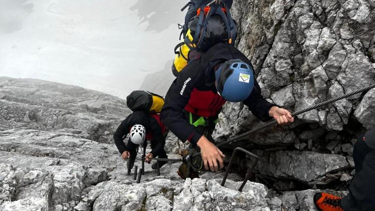 Bergretter beim Abstieg durch den Klettersteig zu den drei Alpinisten