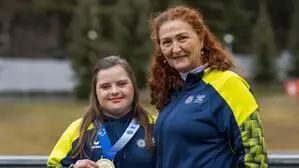 Zwei Frauen schauen in die Kamera. Eine Dame hat eine Goldmedaille um den Hals.