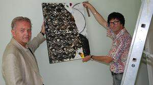 Karl Anton Rezac und Künstler Rudi Benétik beim Hängen eines Bildes für die Ausstellung