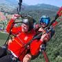 Zwei Personen hoch über dem Boden im Tandemflug am Gleitschirm