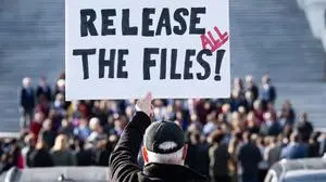 A protester holds a sign related to the release of the Jeffrey Epstein case files outside the US Capitol in Washington, DC, November 12, 2025. Democrats released emails Wednesday in which Jeffrey Epstein suggested Donald Trump was aware of the disgraced financier's sexual abuse and had "spent hours" with one of his victims at his house. Trump has denied any knowledge of the sex-trafficking activities of his former friend, who died by suicide in 2019 as he was in prison awaiting trial, and the White House accused Democrats of pushing a "fake narrative" by sharing the mails. (Photo by SAUL LOEB / AFP)