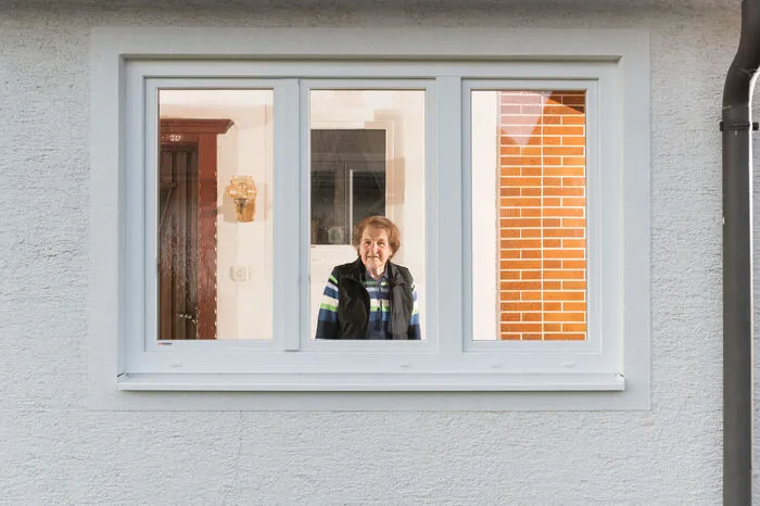 „Bei einem Besuch meiner Schwiegeroma (hier im Bild) kam mir die Idee, sie durch das Fenster, durch das wir gesprochen haben, zu porträtieren. Seither suche ich jeden Tag Freunde und Bekannte auf, um ihr Leben in dieser Zeit festzuhalten“, sagt Pöschl, der dabei jedoch nie Räume betritt.