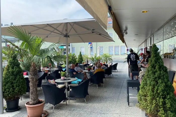 Cafe Sylvia Direkt am Hauptbahnhof laden Palmen und Farne zu einem Getränk in Sylvias Gastgarten am Bahnhofsplatz 2 ein. Im Gastgarten versteckt man sich vor dem lauten Alltagstrubel rund herum, das Cafe hat außerdem täglich von morgens bis abends geöffnet.