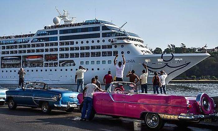 Stilecht warten kubanische Oldtimer auf die ankommenden Touristen