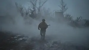 Ein Soldat der russischen Armee geht durch nassen, schlammigen Boden. Er ist in eine Nebelwolke gehüllt.