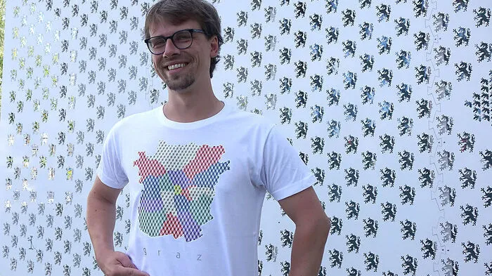 David Kraxner hat den Stadtplan von Graz in farbigen Bezirken am T-Shirt