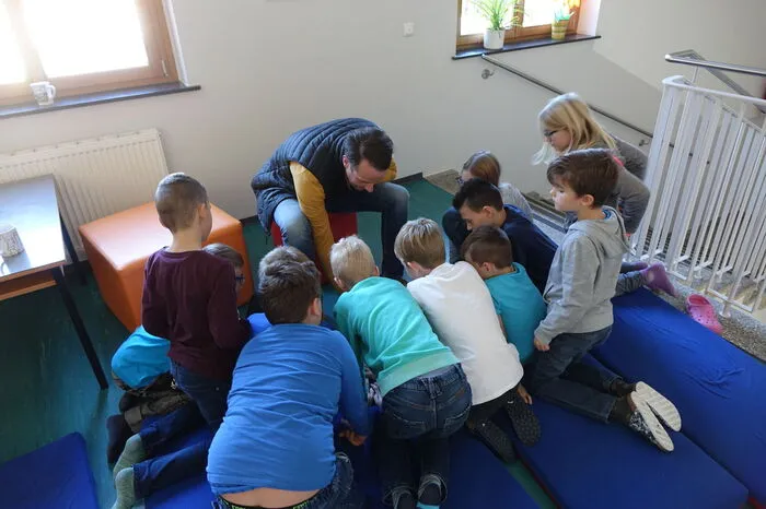Um Punkt 10 Uhr geht es los! Die Kinder der 3. und 4. Klasse versammeln sich rund um ein Tablett, um den Live-Auftritt von Thomas Brezina auf Youtube zu verfolgen.