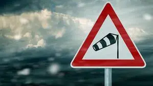 Wind-Warnschild und dahinter ein grauer Himmel