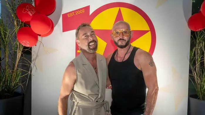 Zwei Männer in einer Partylocation lächeln in die Kamera