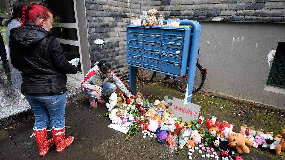 Eine Frau legte zum Gedenken an die toten Kinder Blumen und Kerzen an einem Briefkasten ab. In einer Wohnung des Hauses wurden im September 2020 fünf tote Kinder gefunden