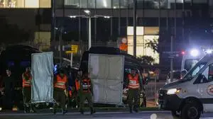 Israeli security forces carry privacy screens at the helipad outside Tel Aviv's Schneider medical centre on November 24, 2023, amid preparations for the release of Israeli hostages held by Hamas in Gaza in exchange for Palestinian prisoners later in the day. After 48 days of gunfire and bombardment that claimed thousands of lives, a four-day truce in the Israel-Hamas war began on November 24 with 50 hostages set to be released in exchange for 150 Palestinian prisoners. (Photo by JACK GUEZ / AFP)
