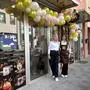 Zwei Frauen stehen vor einem Lokal, dessen Eingang mit Luftballons geschmückt ist