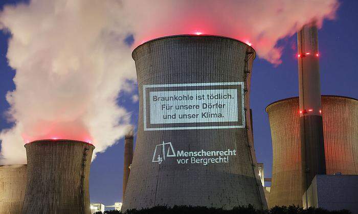 Diesen Schriftzug haben Umweltaktivisten im September auf den Kohlelturm des RWE- Braunkohlekraftwerks Neurath in Nordrhein-Westfalen projiziert. Sie fordern einen schnelleren Kohleausstieg.