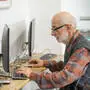 Senior man working on computer at desk. Focused senior man working on computer at desk. model released