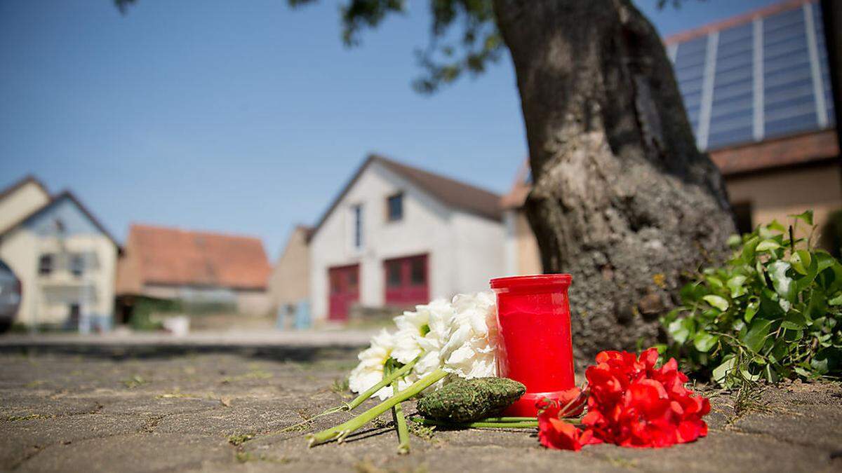 Blumen und eine Kerze am Tatort in Tiefenthal-Leutershausen