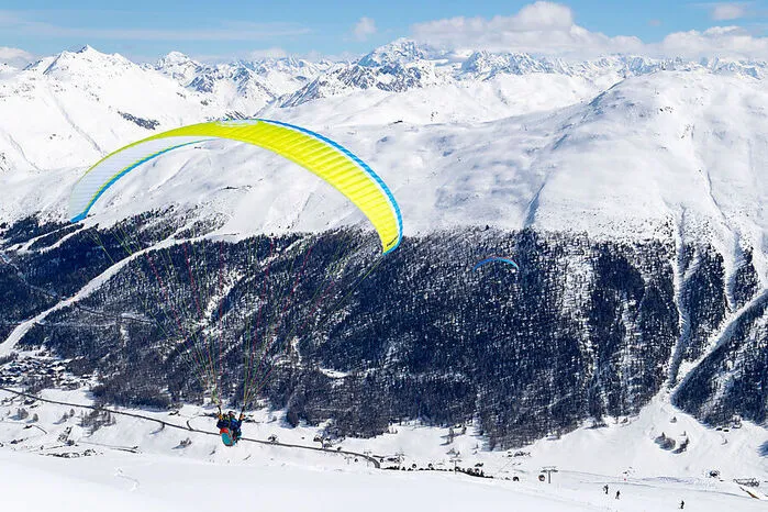 Gleitschirmfliegen. Für diejenigen, die gerne fliegen und raus aus dem Alltag möchten, ist der aufregendste Sport sicherlich das Gleitschirmfliegen. Dank Livignos "Feel the Sky" können sich Flugbegeisterte zwischen die Gipfel der verschneiten Alpen stürzen und über malerische, schneebedeckte Landschaften fliegen.