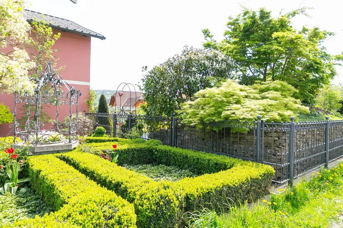 Im Vorgarten wurde ein Kreuzgang mit Buchs udn Ysander um den bestehenden, vom Hausherrn geschmiedeten Brunnen angelegt.