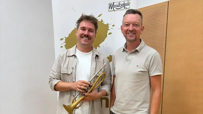 Beide stehen nebeneinander und lachen in die Kamera