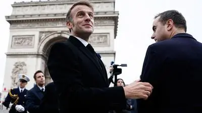 France's President Emmanuel Macron and France's Prime Minister Sebastien Lecornu (R), attend a ceremony at the Arc de Triomphe in Paris, on November 11, 2025, as part of the commemorations marking the 107th anniversary of the November 11, 1918, Armistice, ending World War I (WWI). (Photo by Benoit Tessier / POOL / AFP)