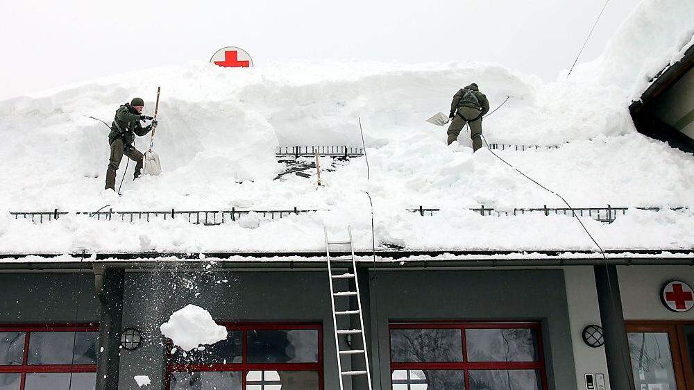 Kärntner Soldaten schaufeln Dach ab
