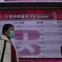 People walk past a bank electronic board showing the Hong Kong share index at Hong Kong Stock Exchange Monday, Feb. 3, 2020. The Shanghai Composite index tumbled 8.7% Monday then rebounded slightly as Chinese regulators moved to stabilize markets reopening from a prolonged national holiday despite a rising death toll from a new virus that has spread to more than 20 countries. (AP Photo/Vincent Yu)