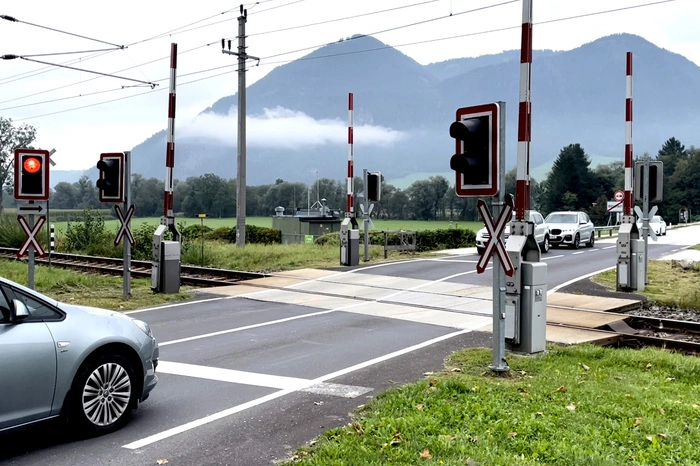 Die Schranken sind nach dem Passieren des Zuges praktisch oben, das Rotlicht leuchtet noch. Wer jetzt schon ungeduldig angefahren und Sekundenbruchteile zu früh über die Line gefahren ist, wird kräftig zur Kasse gebeten.