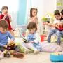 Kindergarten teacher with children on music lesson in day care. Little kids toddlers play together with developmental toys.; sujet