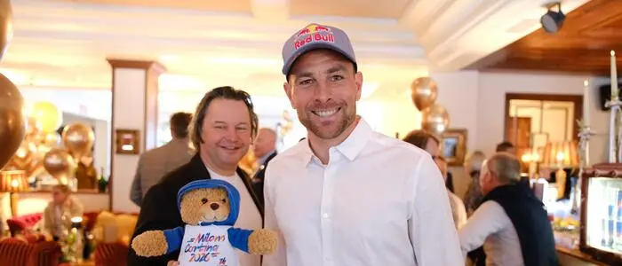 Benjamin Karl mit einem Fan sowie dem Olympia-Maskottchen