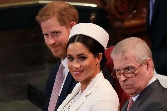 In der zweiten Reihe: Prince Harry und die werdende Mutter Meghan in strahlendem Weiß.