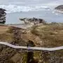 (FILES) Visitors to the Icefjord Centre (Kangiata Illorsua) in Greenland walk along the boardwalk taking them to the icebergs and glacier in Ilulissat on June 29, 2022. A mile-thick (1.6-km) ice sheet in Greenland vanished around 416,000 years ago during a period of moderate natural warming, driving global sea rise to levels that would spell catastrophe for coastal regions today, a study said on July 20, 2023. The results overturn a long held view that the world's largest island was an impregnable fortress of ice over the past 2.5 million years, and instead show it will be far more vulnerable to human-caused climate change than previously thought. "If we want to understand the future, we need to understand the past," University of Vermont scientist Paul Bierman, who co-led the paper published in Science, told AFP. (Photo by Odd ANDERSEN / AFP)