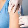 Vaccine in injection needle. Doctor working with patient's arm. Physician or nurse giving vaccination and immunity to virus, influenza or HPV with syringe. Appointment with medical expert. Close-up