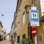 Blick in eine Gasse mit niedrigen Häusern, davor Schilder, die auf die Fußgängerzone und die polizeiliche Kameraüberwachung hinweisen