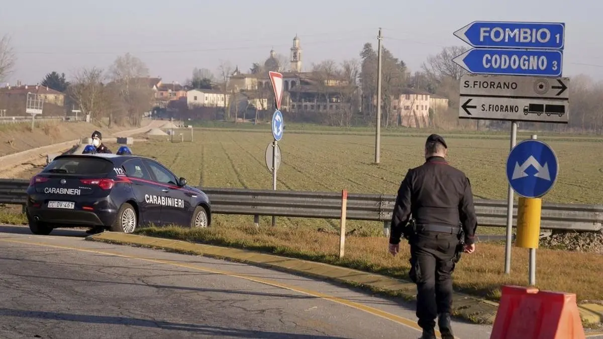 Carabinieri (Italian paramilitary police) officers set a road block in Codogno, Northern Italy, Monday, Feb. 24, 2020. Italy scrambled to check the spread of Europe's first major outbreak of the new viral disease amid rapidly rising numbers of infections and a third death. Road blocks were set up in at least some of 10 towns in Lombardy at the epicenter of the outbreak, to keep people from leaving or arriving. (AP Photo/Paolo Santalucia)