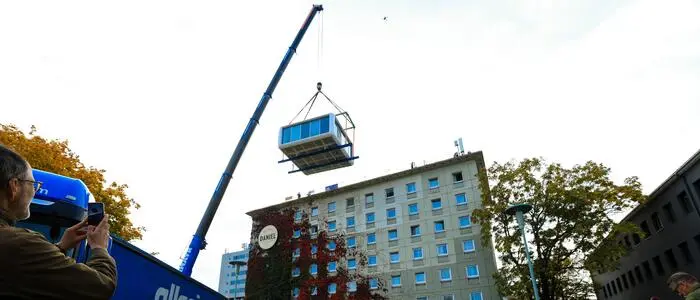 Ein Kran hievt das 18 Tonnen schwere Zimmer nach oben
