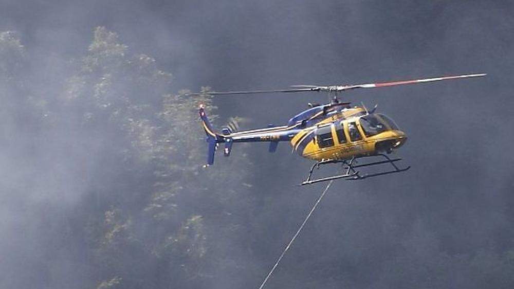 Hubschrauber fliegen mit Löschwasser zur Absturzstelle